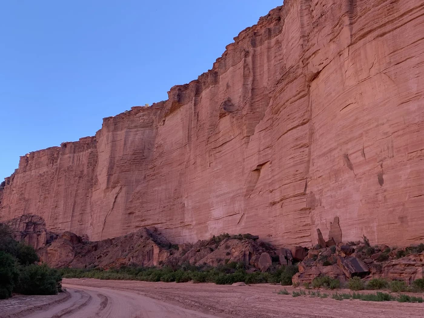 Photo d'origine : une falaise de grès rouge au-dessus d'une piste de sable